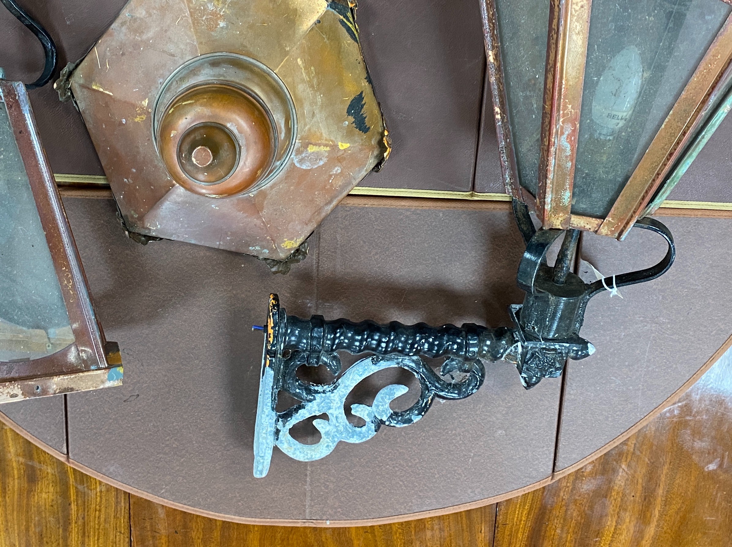 A pair of copper wall lanterns with black painted metal wall brackets, height 98cm